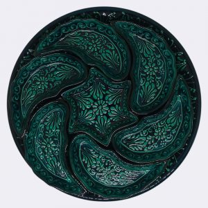 Rüzgar gülü çini çerezliğin bir bölmesi üzerindeki el işçiliği desenlerin yakından görünümü.